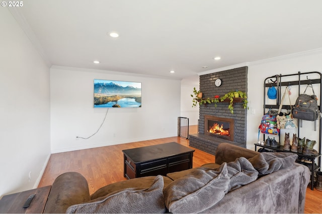 living area with crown molding, a fireplace, light wood-style floors, recessed lighting, and baseboards