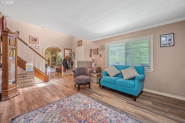 20685 SW Siletz Ct, Tualatin, OR 97062 - living room featuring stairs, arched walkways, wood finished floors, crown molding, and baseboards
