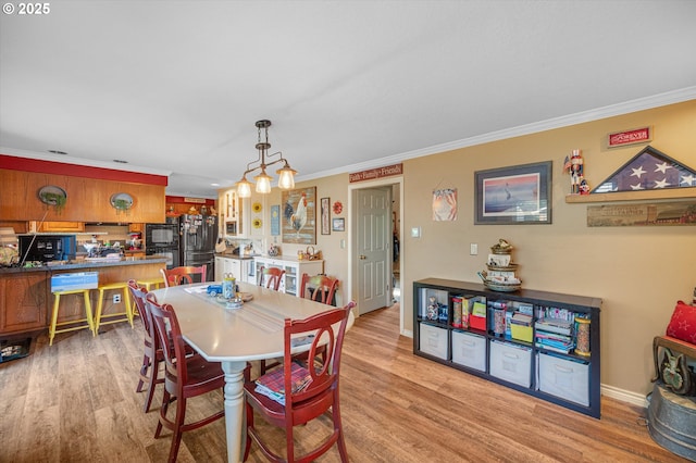 20685 SW Siletz Ct, Tualatin, OR 97062 - dining space featuring light wood-style flooring, ornamental molding, baseboards, and a chandelier