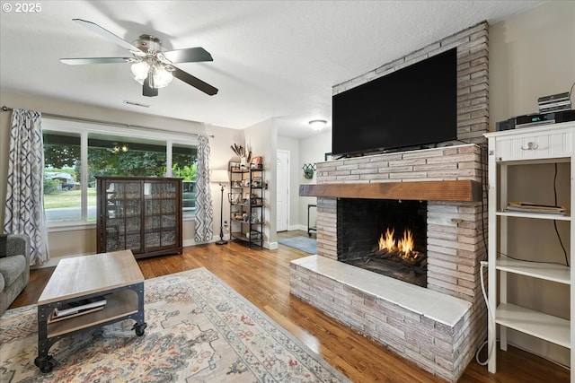 3002 17th Ave, Forest Grove, OR 97116 - living room featuring ceiling fan, a fireplace, wood finished floors, and a textured ceiling