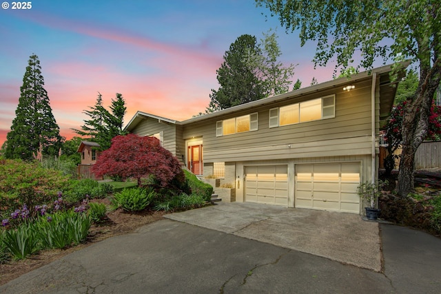 raised ranch with asphalt driveway and an attached garage