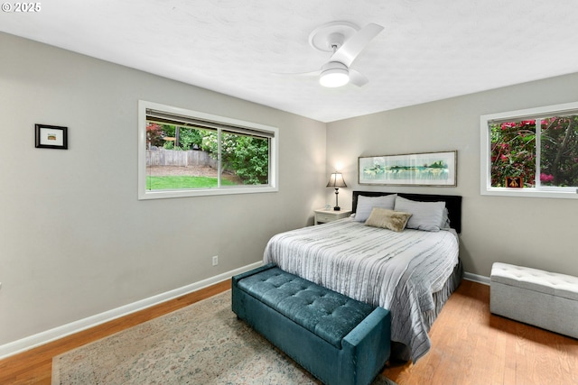 bedroom with baseboards, wood finished floors, and a ceiling fan