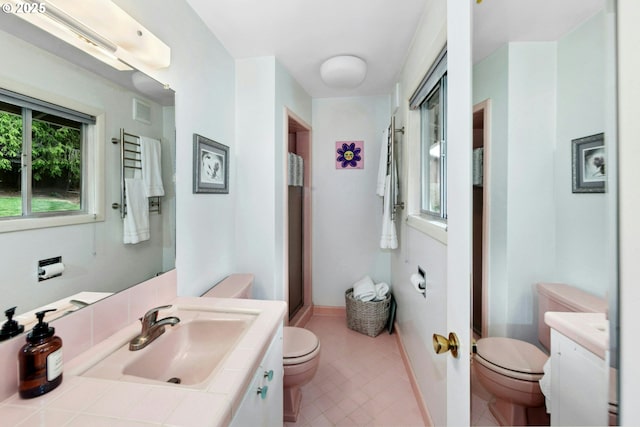 bathroom with toilet, tile patterned floors, vanity, and baseboards