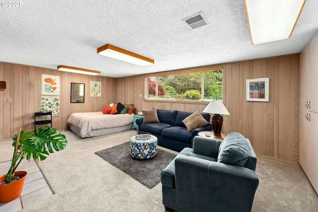 carpeted living room featuring wooden walls and a textured ceiling