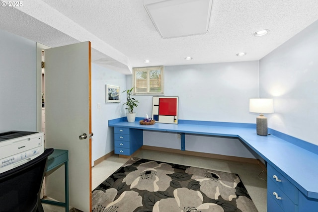office area featuring a textured ceiling, recessed lighting, and built in desk