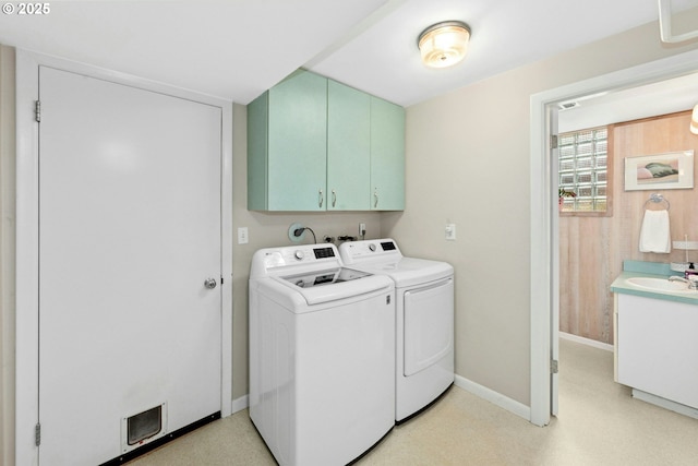 clothes washing area with washer and dryer, cabinet space, baseboards, and light flooring