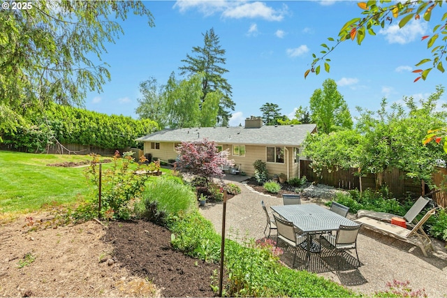 back of house with a patio, outdoor dining space, and a chimney