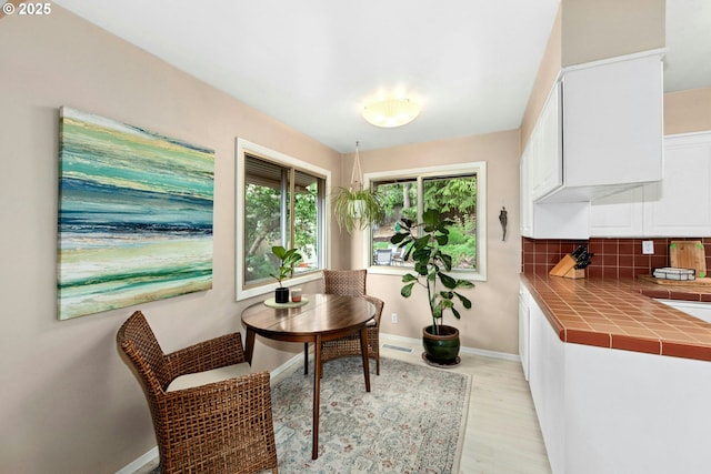 dining room with light wood-type flooring and baseboards