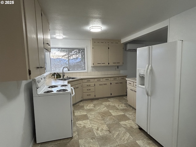 kitchen with white appliances, stone finish flooring, light countertops, a textured ceiling, and a sink