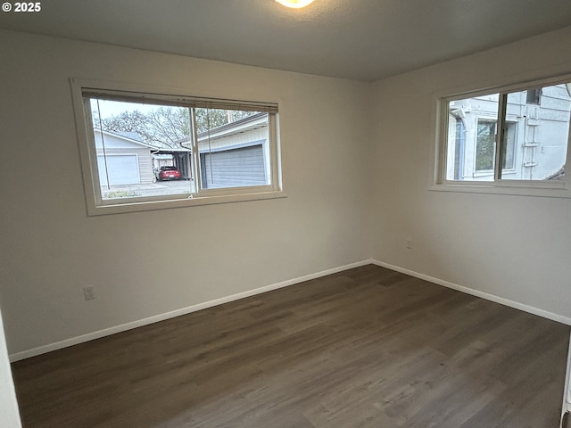 unfurnished room with baseboards and dark wood finished floors