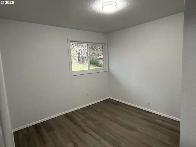 unfurnished room featuring a textured ceiling, baseboards, and dark wood-type flooring