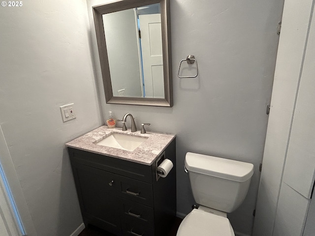 half bathroom featuring toilet and vanity