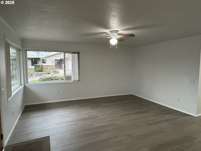 empty room with dark wood-style flooring, ceiling fan, a textured ceiling, and baseboards