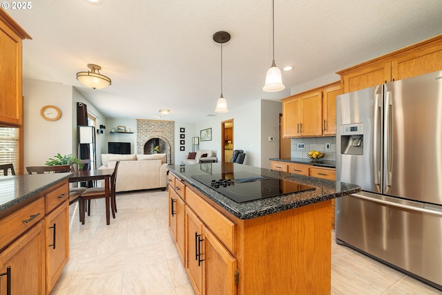 12015 SE Regal Ct, Clackamas, OR 97015 - kitchen with stainless steel fridge, black electric cooktop, a center island, decorative light fixtures, and a fireplace