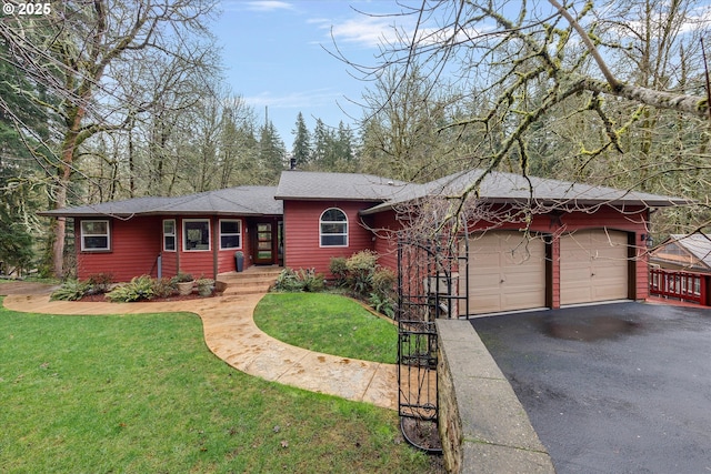 view of front of house with driveway, an attached garage, and a front lawn