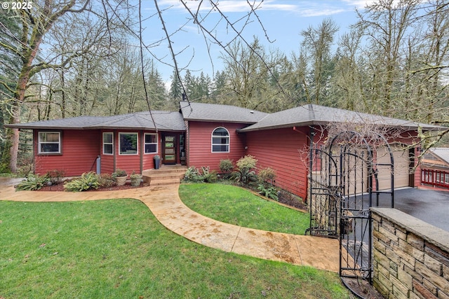 view of front of property featuring a front yard, driveway, and an attached garage