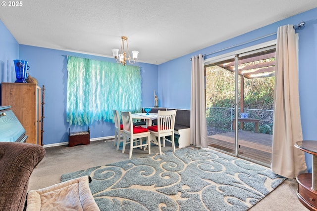 carpeted dining area featuring a chandelier and a textured ceiling