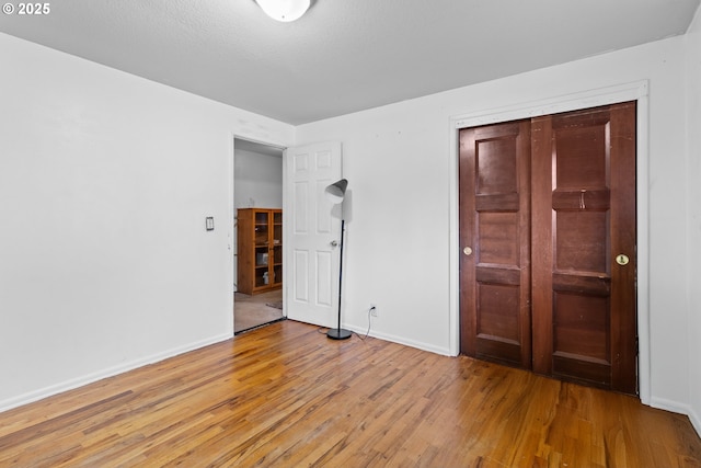 unfurnished bedroom featuring hardwood / wood-style flooring and a closet