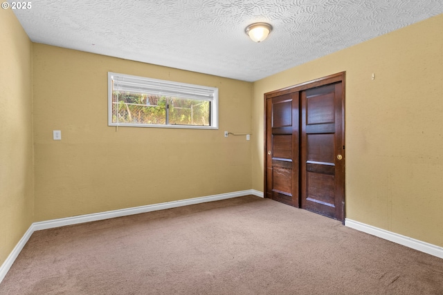 empty room with carpet flooring and a textured ceiling