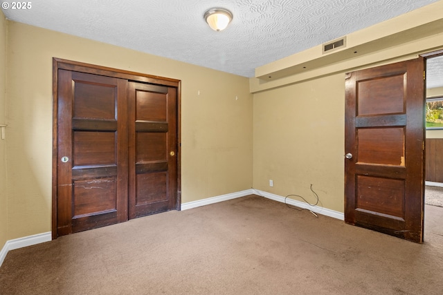 carpeted spare room with a textured ceiling