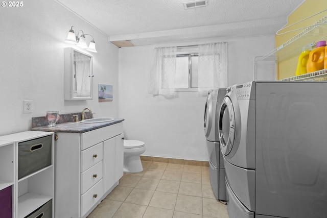 bathroom featuring tile patterned floors, washing machine and dryer, toilet, a textured ceiling, and vanity