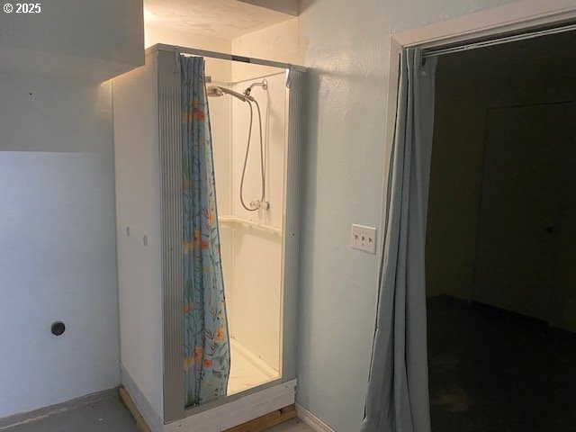 bathroom with a shower with curtain and baseboards