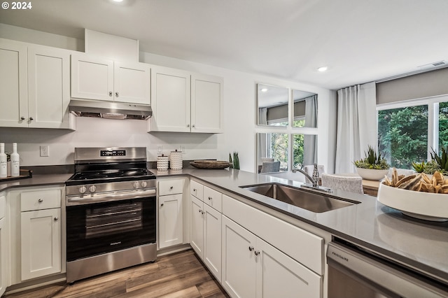 kitchen featuring under cabinet range hood, a sink, white cabinetry, dishwasher, and stainless steel range with electric stovetop