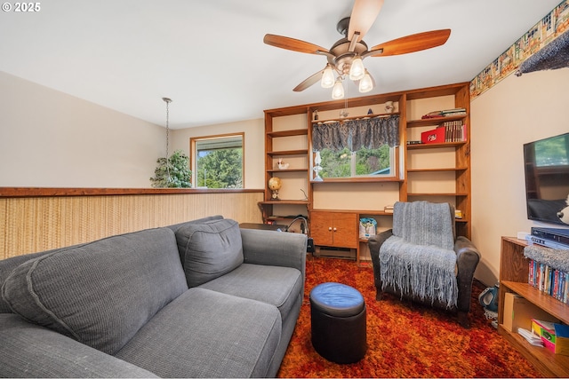 living room with carpet flooring, ceiling fan, and a baseboard heating unit