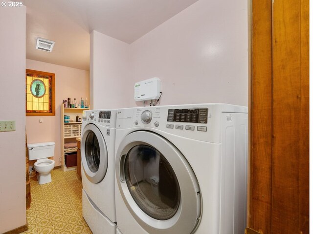 clothes washing area featuring visible vents, laundry area, light floors, and washing machine and clothes dryer