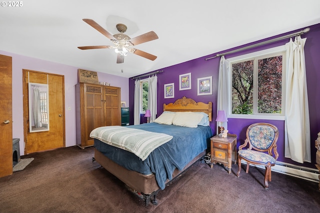 carpeted bedroom with ceiling fan and a baseboard heating unit