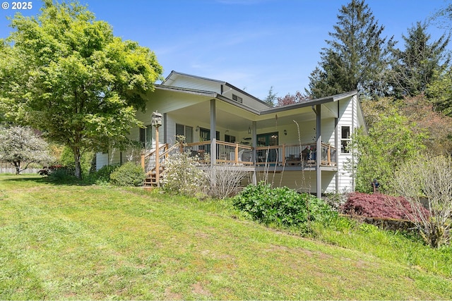rear view of property featuring a lawn and a porch