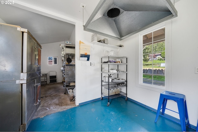 interior space with finished concrete floors, baseboards, and lofted ceiling