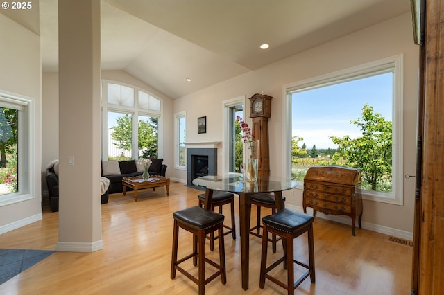 20700 SE Cherry Blossom Ln, Amity, OR 97101 - dining area featuring plenty of natural light, a fireplace with flush hearth, light wood-style floors, and lofted ceiling