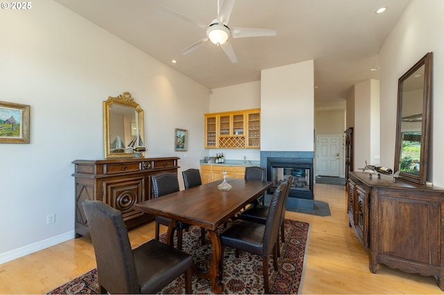 20700 SE Cherry Blossom Ln, Amity, OR 97101 - dining space with light wood-type flooring, a ceiling fan, a tiled fireplace, and recessed lighting