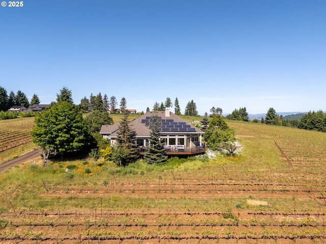 20700 SE Cherry Blossom Ln, Amity, OR 97101 - back of house with roof mounted solar panels, a wooden deck, and a view of rural / pastoral area