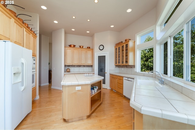 20700 SE Cherry Blossom Ln, Amity, OR 97101 - kitchen featuring white appliances, light brown cabinetry, tile countertops, a center island, and tasteful backsplash