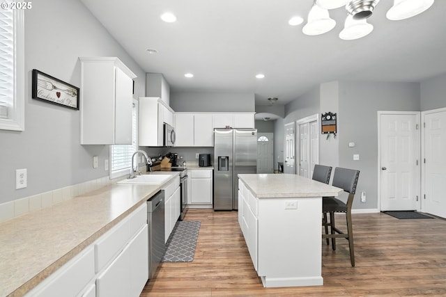 2137 N Q St, Washougal, WA 98671 - kitchen with appliances with stainless steel finishes, a center island, a breakfast bar area, light wood-style floors, and recessed lighting