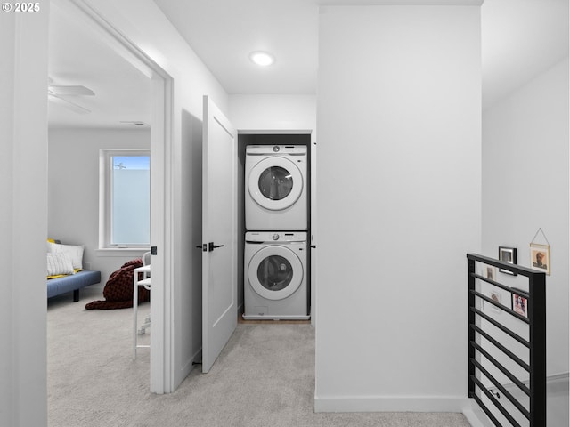 laundry area featuring stacked washing maching and dryer and light colored carpet