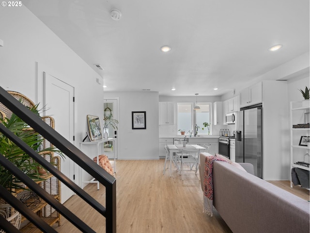 living room with sink and light hardwood / wood-style flooring