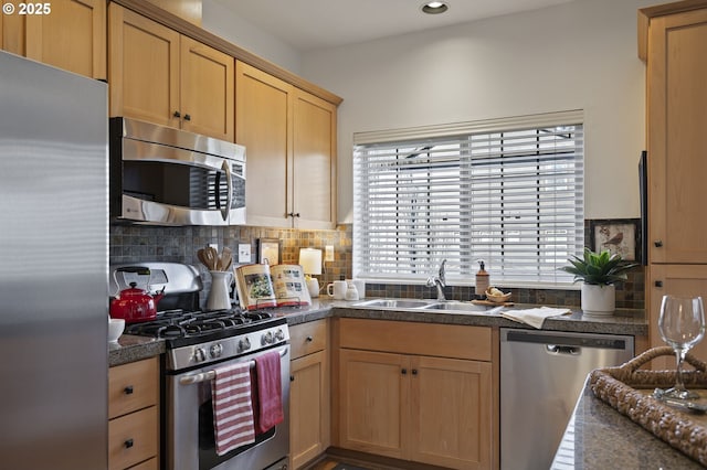 kitchen with appliances with stainless steel finishes, sink, and decorative backsplash