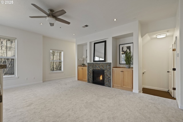 unfurnished living room featuring ceiling fan, a fireplace, and carpet