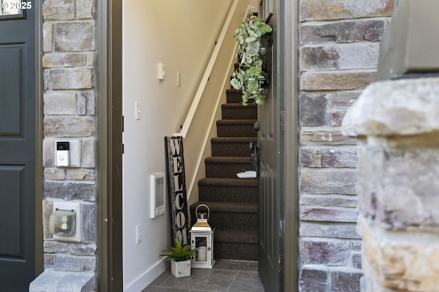 stairway with tile patterned floors