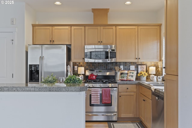 kitchen with stainless steel appliances, tasteful backsplash, sink, and light brown cabinetry