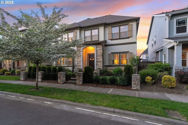 12339 SW Waterford Loop, Wilsonville, OR 97070 - view of front of house with a fenced front yard, stucco siding, and stone siding