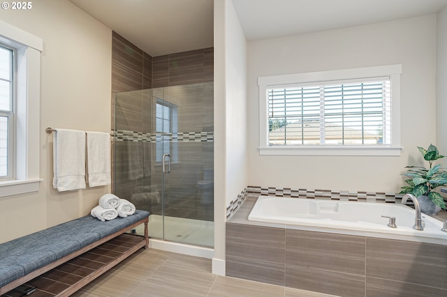 12339 SW Waterford Loop, Wilsonville, OR 97070 - bathroom featuring healthy amount of natural light, a garden tub, a shower stall, and tile patterned floors