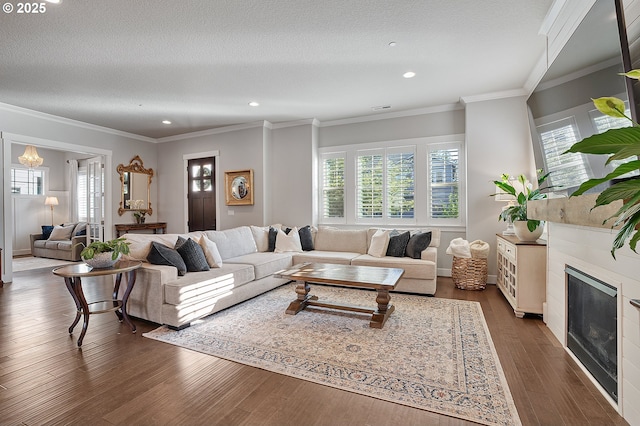 12339 SW Waterford Loop, Wilsonville, OR 97070 - living room with healthy amount of natural light, dark wood finished floors, recessed lighting, a fireplace, and ornamental molding