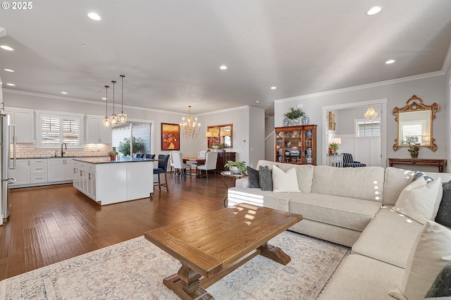 12339 SW Waterford Loop, Wilsonville, OR 97070 - living room featuring a chandelier, recessed lighting, dark wood-style floors, and crown molding