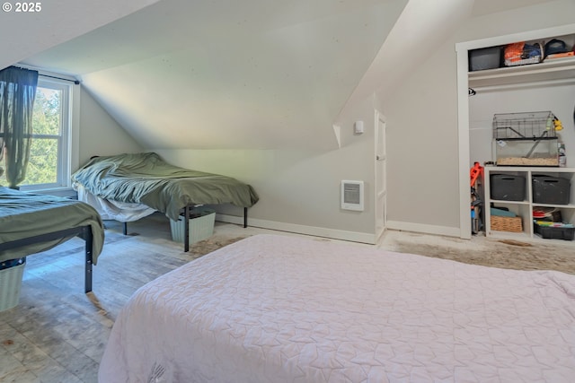 bedroom with vaulted ceiling and heating unit