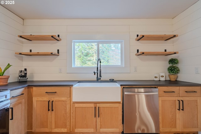 kitchen featuring wood walls, dishwasher, and sink