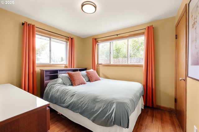 bedroom with wood finished floors and baseboards